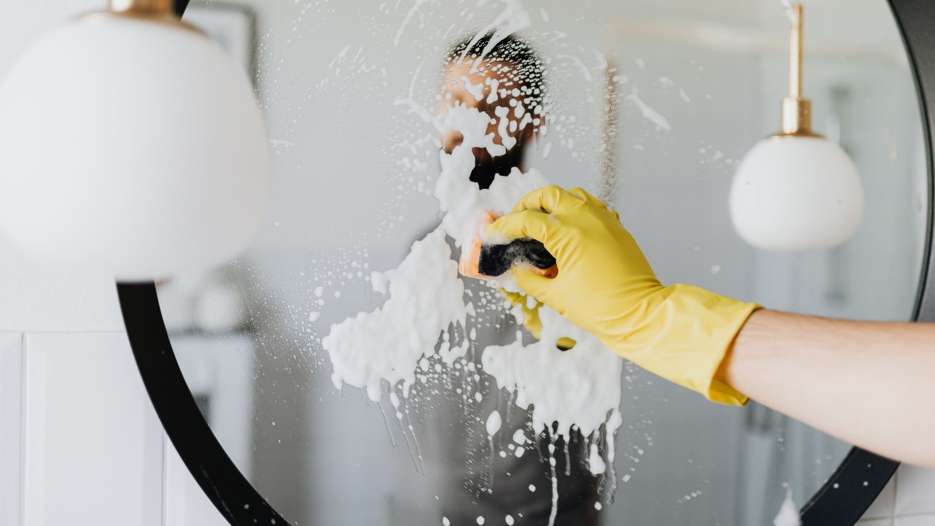 Mirror and glass cleaning close-up with sponge